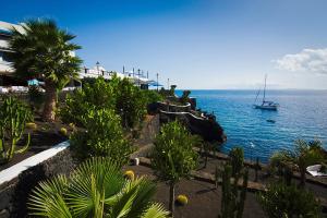 a boat on the water next to a beach at Apartamento Aqua Clara in Puerto del Carmen