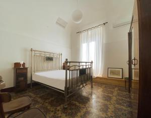 sypialnia z łóżkiem, krzesłem i oknem w obiekcie San Liberale sul mare w Trapani