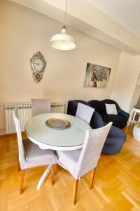 - une table et des chaises blanches dans le salon dans l'établissement Apartment Nera Zadar, à Zadar