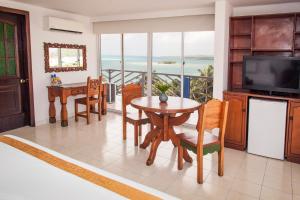 a living room with a table and chairs and a television at Sol Caribe Sea Flower in San Andrés
