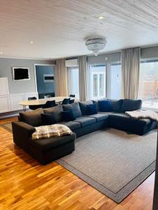 uma sala de estar com um sofá azul e uma mesa em Villa, Barnvänlig, nära strand/shopping em Halmstad