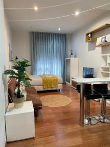 um quarto com uma cama, uma secretária e uma mesa em CarreraHouses Brisa em Vigo