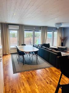 uma sala de estar com uma mesa e um sofá em Villa, Barnvänlig, nära strand/shopping em Halmstad