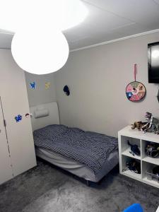 um pequeno quarto com uma cama e uma televisão em Villa, Barnvänlig, nära strand/shopping em Halmstad