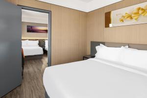 Postel nebo postele na pokoji v ubytování Ly New York Hotel
