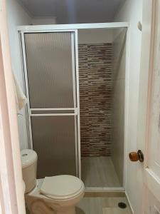 a bathroom with a toilet and a glass shower at Hotel Costa Real in Playa Ladrilleros