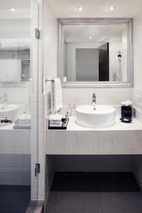 Wyndham Monterrey Ambassador Centro في مونتيري: حمام أبيض مع حوض ومرآة