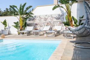 a pool with chaise lounge chairs and a swimming pool at Villa Geraldina con piscina in Torre Suda