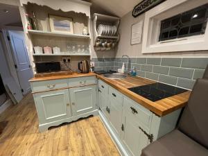 a kitchen with white cabinets and a sink and counters at Jabba The Hut in Sturminster Marshall