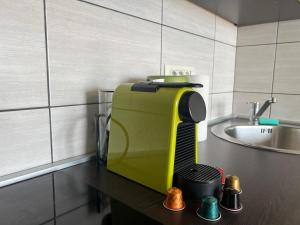 a kitchen with a yellow juicer on a table next to a sink at Perla Apartments Opatija - apartments with sea view in Opatija