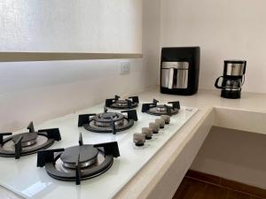 a kitchen counter with a stove top with a coffee maker at Departamento Océano in La Paz +5 photos