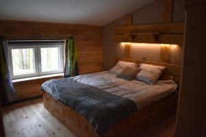 - une chambre avec un grand lit dans une pièce dotée d'une fenêtre dans l'établissement Gite cocon dans la forêt, à Philippeville
