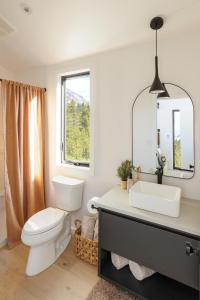 a bathroom with a toilet and a sink and a mirror at Outbound Stowe in Stowe