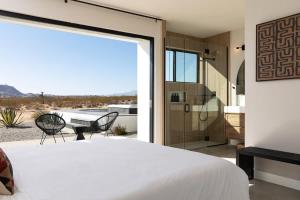Un dormitorio con una cama y una puerta corrediza de vidrio. en SkyDweller - Joshua Tree Modern, en Joshua Tree