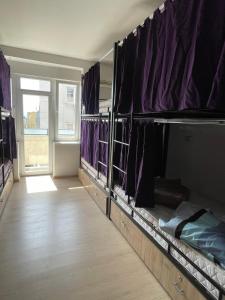 a room with bunk beds with purple curtains at NEWBORN comfort HOSTEL in Pristina