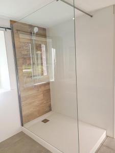 La salle de bains est pourvue d'une douche avec une porte en verre. dans l'établissement Le gîte d'Ouillon, à Saint-Hostien