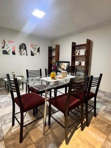 uma sala de jantar com uma mesa de vidro e cadeiras em Departamento em Tarija