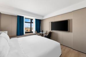 College Point的住宿－Ly New York Hotel，卧室配有白色的床和平面电视。