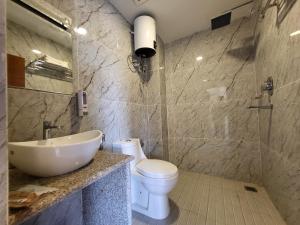 賈奈克布爾的住宿－Anjani Suite，一间带水槽、卫生间和镜子的浴室