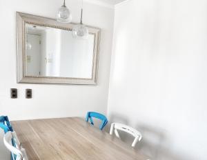 a dining room table with chairs and a mirror at Departamento totalmente equipado a pasos de la Playa y Casino Enjoy in Coquimbo