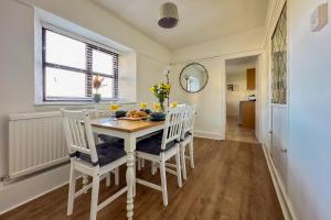 a dining room with a white table and chairs at Cosy Coastal Retreat-Dog Friendly in Worle