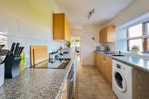 a large kitchen with a washer and dryer in it at Cosy Coastal Retreat-Dog Friendly in Worle