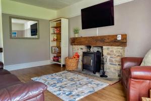 a living room with a stone fireplace with a flat screen tv at Cosy Coastal Retreat-Dog Friendly in Worle
