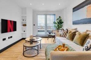 a living room with a couch and a table at homely- North London Penthouse Apartment Finchley in Finchley