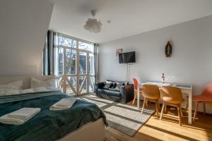 1 dormitorio con 1 cama, mesa y sillas en SOLEMAR romantic studio with lagoon View!, en Pervalka