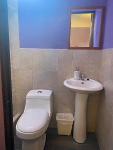 y baño con aseo y lavamanos. en Hotel Quinta Vista Verde, en Antigua Guatemala