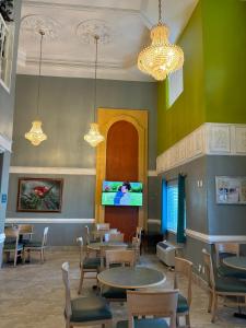 restauracja ze stołami i krzesłami oraz telewizorem z płaskim ekranem w obiekcie Deluxe Inn & Suites w mieście Brownsville