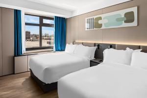 Postel nebo postele na pokoji v ubytování Ly New York Hotel