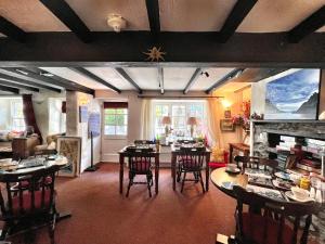 a living room with tables and chairs and a fireplace at The Cottage Bed & Breakfast in Polperro