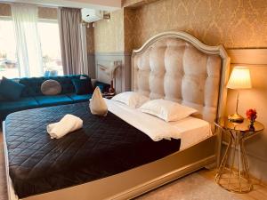 Un dormitorio con una cama grande y un sofá. en Air Residence 4, en Otopeni