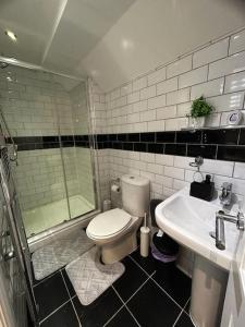 ein Bad mit einer Dusche, einem WC und einem Waschbecken in der Unterkunft Lovely 5BR Home in Manchester. Close to the City in Manchester