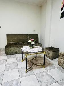 uma sala de estar com um sofá e uma mesa com flores em Departamento em Tarija