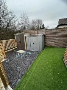 een achtertuin met een hek en een tuin met groen gras bij Lovely 5BR Home in Manchester. Close to the City in Manchester