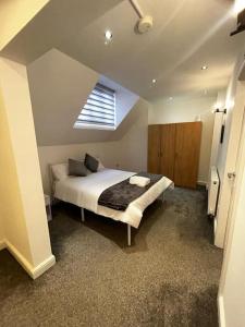 een slaapkamer met een groot bed en een raam bij Lovely 5BR Home in Manchester. Close to the City in Manchester