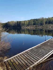 un muelle en un lago con árboles en el fondo en Villa Svalan, en Hällefors