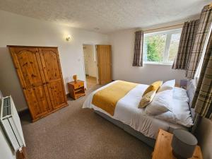 a bedroom with a large bed and a window at Raphael House in Pembrey