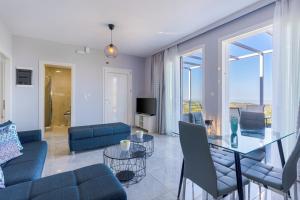 un soggiorno con divano blu e tavolo in vetro di Sun Angelo luxury apartment in Paradise 1 ad Arménoi