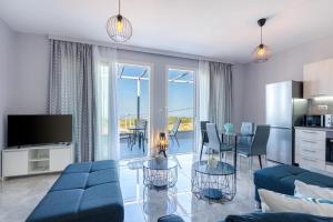 un soggiorno con divano e tavolo con sedie di Sun Angelo luxury apartment in Paradise 1 ad Arménoi