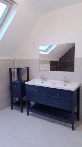 a bathroom with a blue sink and a mirror at Maison agréable et spacieuse dans le Loiret in Sully-sur-Loire