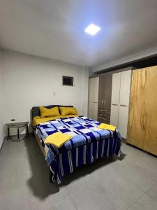 um quarto com uma cama com lençóis amarelos e azuis em Departamento em Tarija