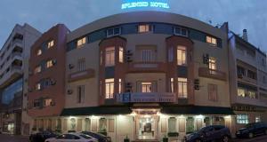 un gran edificio con coches estacionados frente a él en Hotel Splendid, en Fez