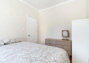 um quarto branco com uma cama e uma cómoda em Spacious 1BR Apartment em Nova York