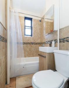 uma casa de banho com um WC, uma banheira e um lavatório. em Spacious 1BR Apartment em Nova York