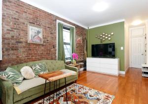 uma sala de estar com um sofá e uma parede de tijolos em Spacious 1BR Apartment em Nova York