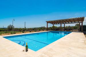 eine Flasche Wein neben einem Pool in der Unterkunft Villa Darder , Sa garriga in Ariany