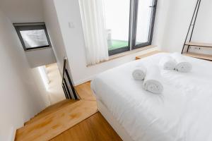 uma cama branca num quarto com uma janela em Castle Palm View em Leiria